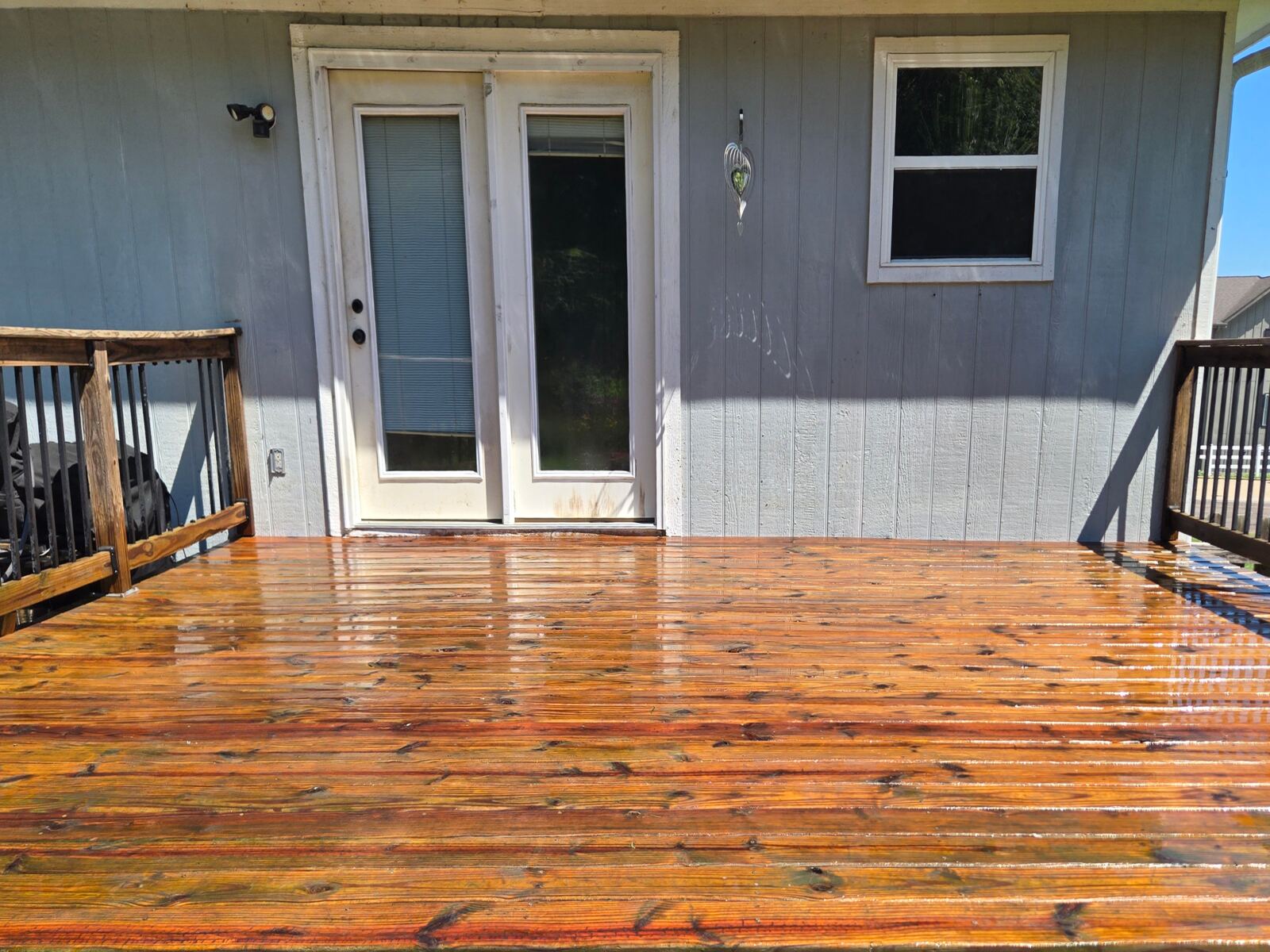 Wood deck by sliding door before pressure washing in Kansas City