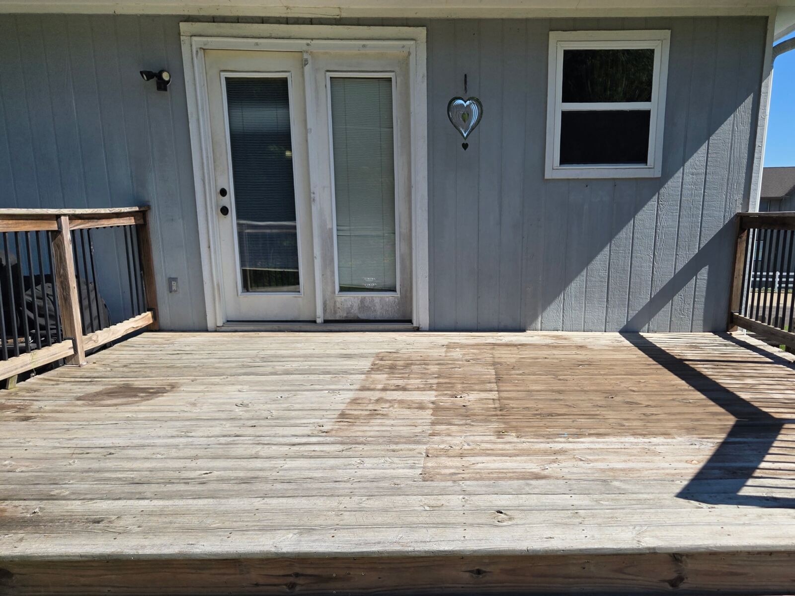 Wood deck by sliding door after pressure washing and staining in Kansas City